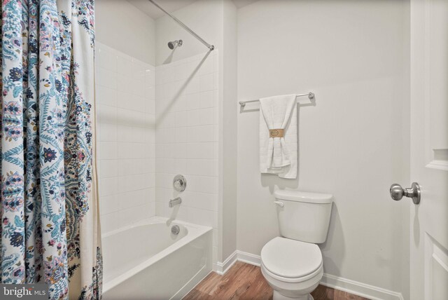 bathroom with toilet, hardwood / wood-style floors, and shower / bath combo