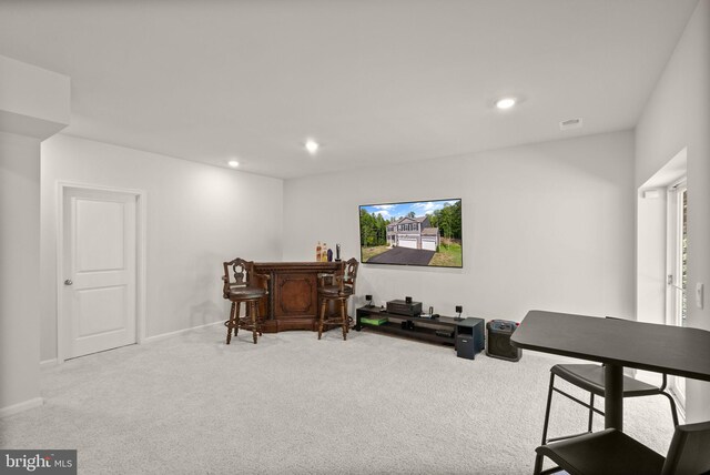 sitting room featuring bar and carpet floors