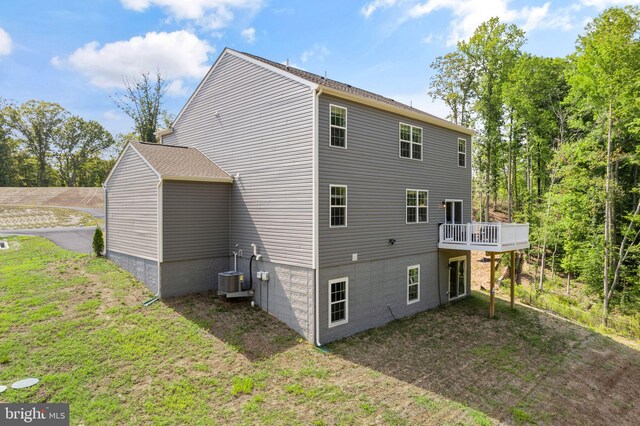 back of property featuring central air condition unit and a yard