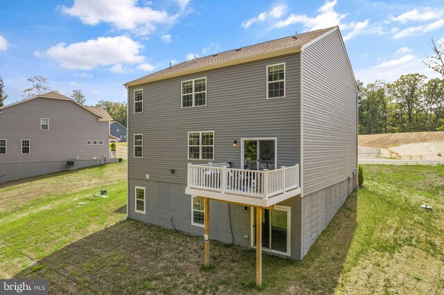 rear view of property with a yard and a wooden deck