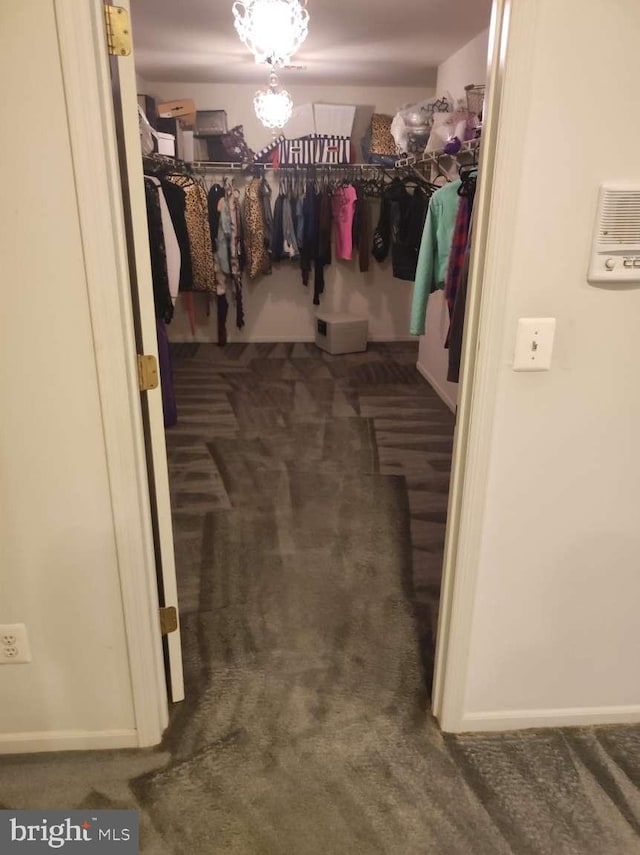 walk in closet featuring dark carpet