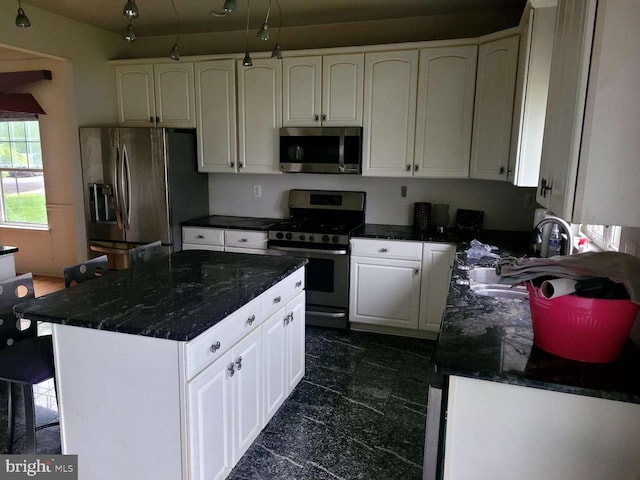 kitchen with sink, white cabinets, dark stone counters, and appliances with stainless steel finishes