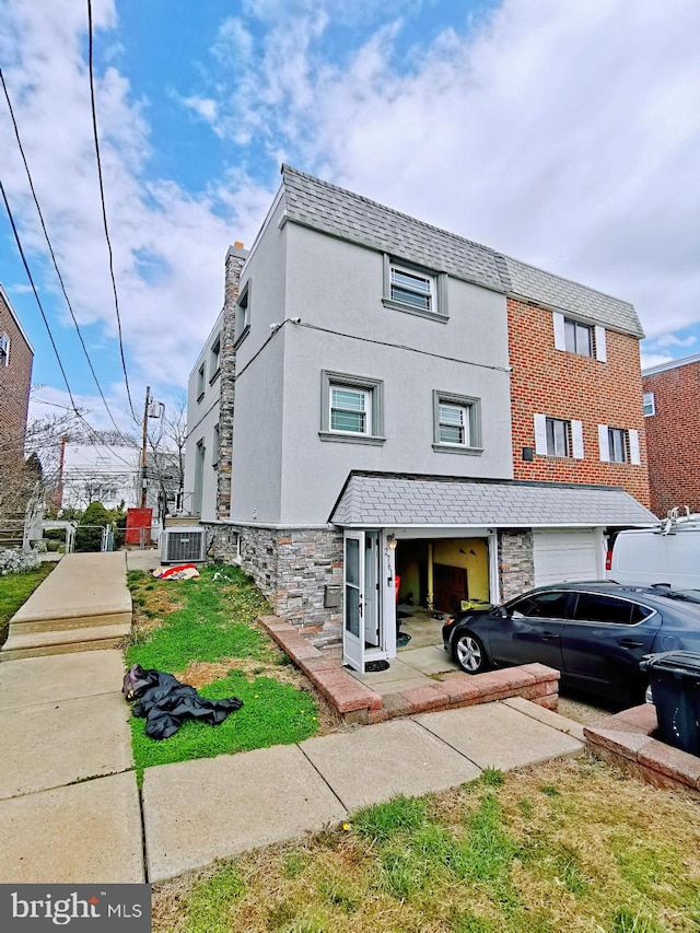 view of property featuring a garage and cooling unit