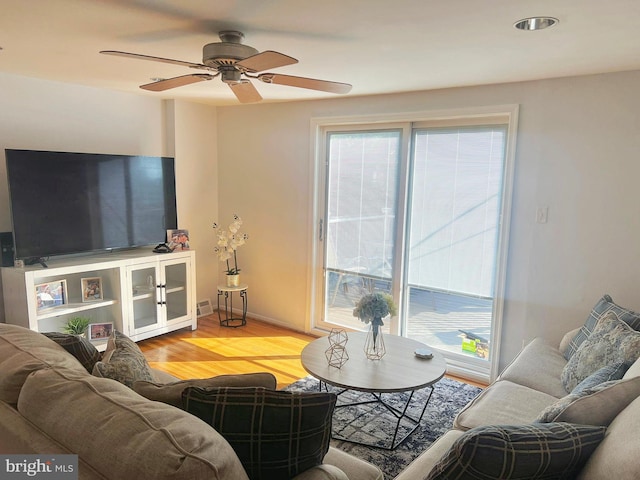 living room with ceiling fan, light wood-type flooring, and plenty of natural light