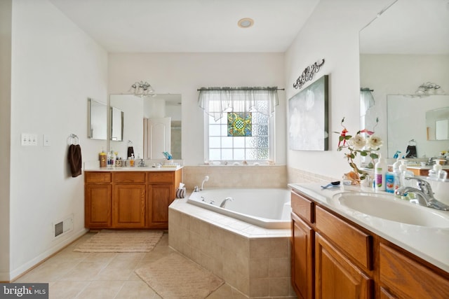 bathroom with a relaxing tiled tub, tile patterned floors, and vanity