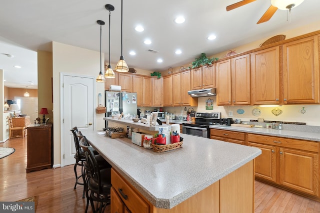 kitchen with light hardwood / wood-style flooring, electric range oven, stainless steel fridge, a center island, and ceiling fan