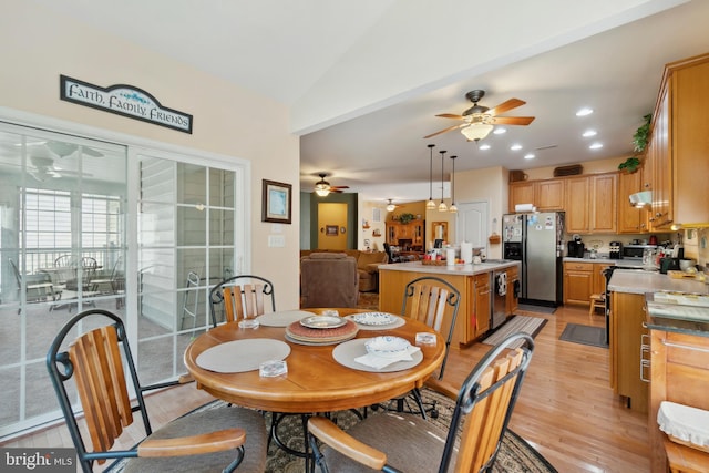 dining area with ceiling fan, light hardwood / wood-style floors, and lofted ceiling