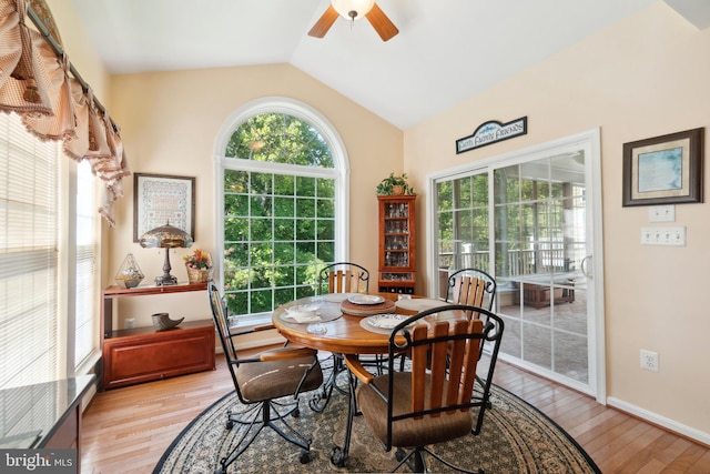 dining area featuring vaulted ceiling, light wood-type flooring, and plenty of natural light