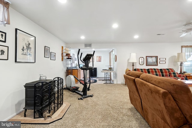 exercise room featuring ceiling fan and light colored carpet