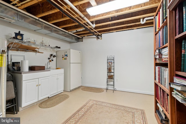 basement with sink and white refrigerator