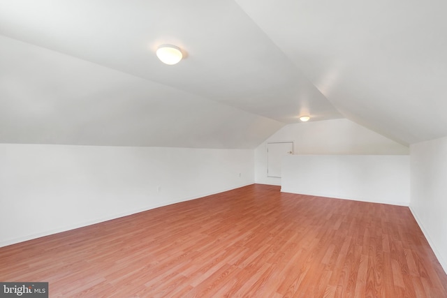 bonus room featuring lofted ceiling and light wood-type flooring