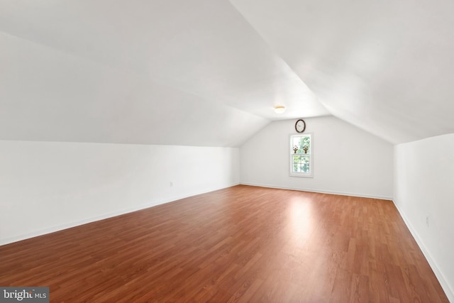 bonus room with vaulted ceiling and wood-type flooring