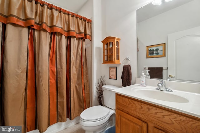 bathroom with vanity, walk in shower, and toilet