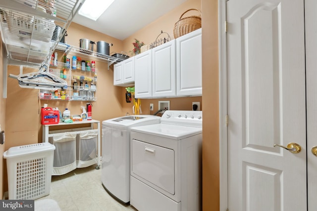 laundry room featuring washing machine and dryer, cabinets, and light tile patterned floors