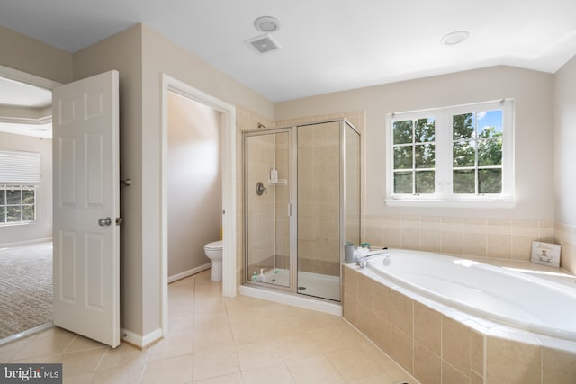 bathroom featuring toilet, independent shower and bath, tile patterned flooring, and a healthy amount of sunlight