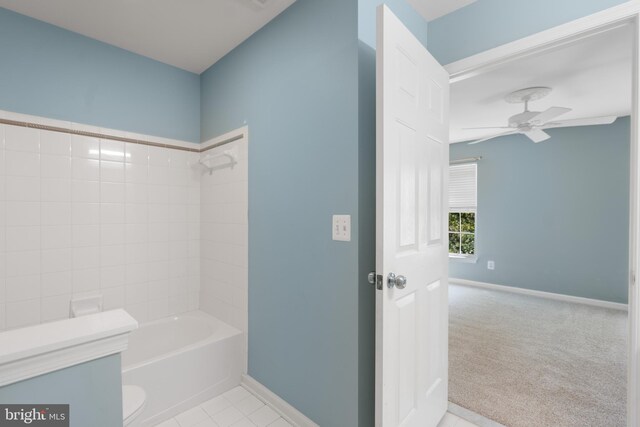 bathroom featuring toilet, ceiling fan, tiled shower / bath, and tile patterned floors