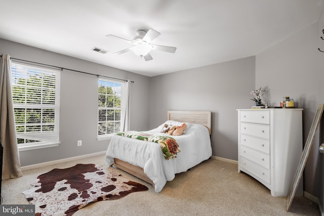 bedroom with ceiling fan and light carpet