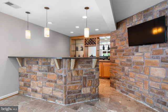 bar with hanging light fixtures and tile patterned flooring