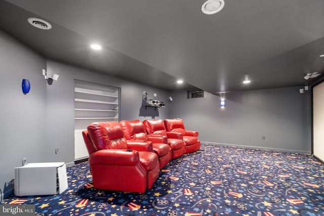 carpeted cinema room featuring built in shelves