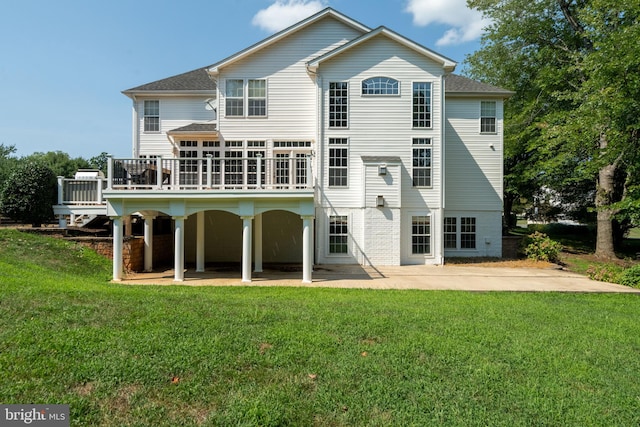 back of house with a lawn, a patio area, and a wooden deck