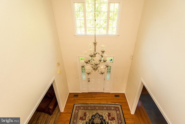 foyer with visible vents, baseboards, and wood finished floors