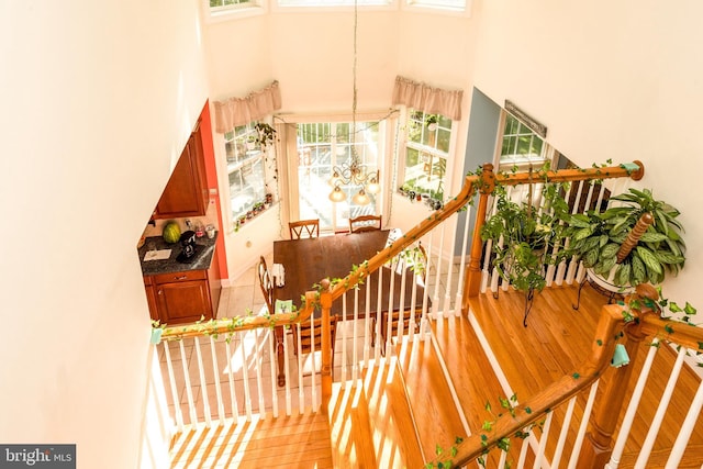 stairway featuring a towering ceiling and an inviting chandelier