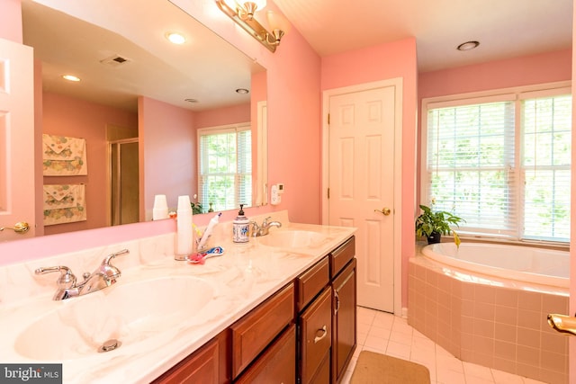 bathroom with tile patterned flooring, a wealth of natural light, separate shower and tub, and vanity