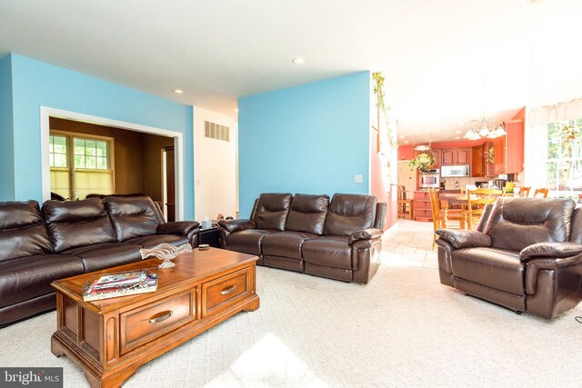 living room with light carpet and a chandelier