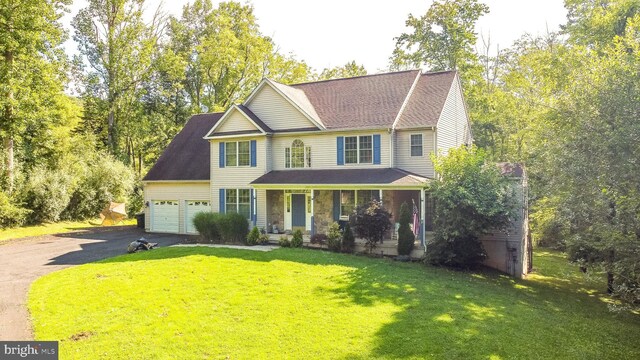 colonial inspired home with a garage, a front yard, and a porch