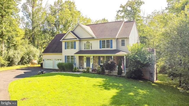 view of front of house with a porch, a front yard, driveway, and a garage