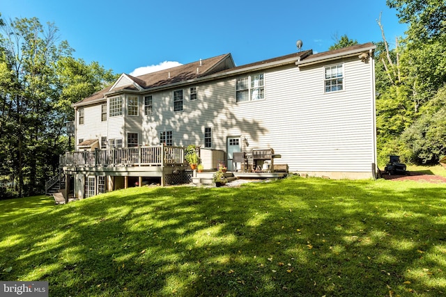 rear view of property with a yard and a deck