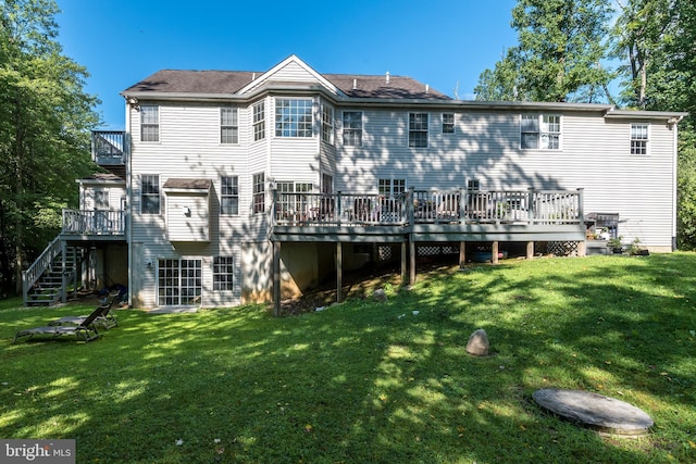 rear view of property with stairs, a deck, and a yard