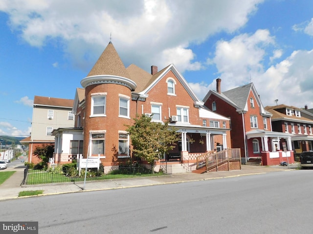 view of front of house featuring brick siding, a fenced front yard, a chimney, and a residential view