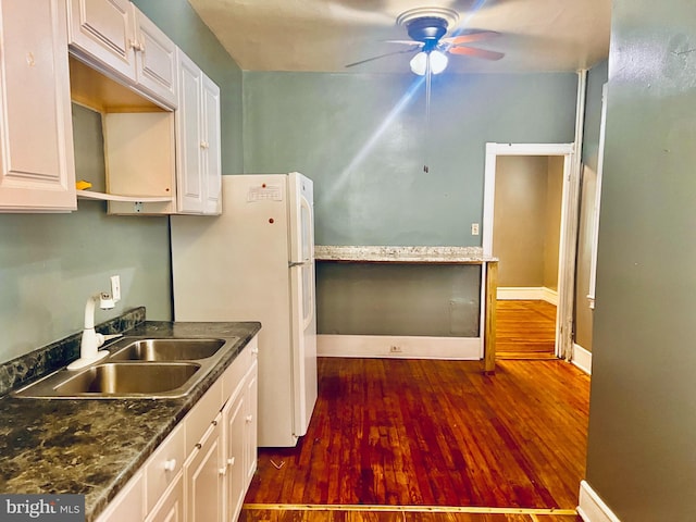 kitchen with ceiling fan, sink, white fridge, white cabinets, and dark hardwood / wood-style floors