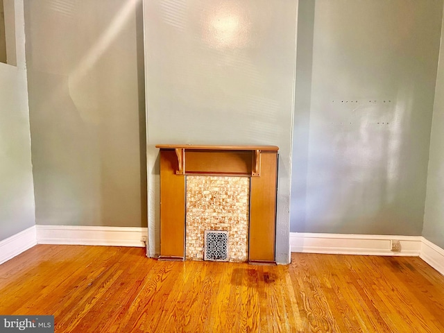 unfurnished living room with a fireplace and light wood-type flooring