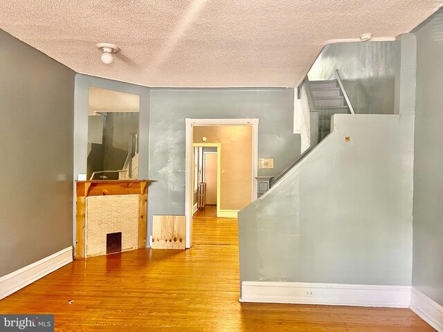 hallway with a textured ceiling and hardwood / wood-style flooring