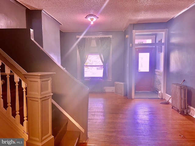 foyer featuring radiator heating unit and hardwood / wood-style floors