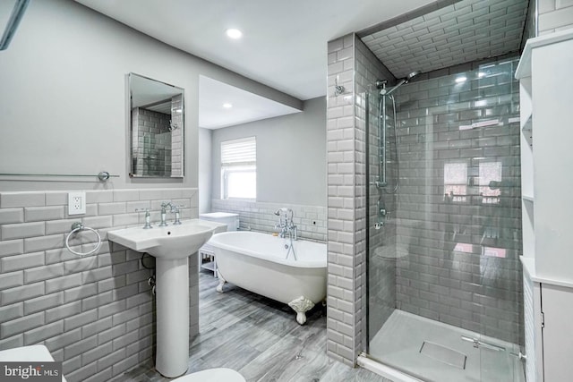 bathroom featuring tile walls, independent shower and bath, and wood-type flooring