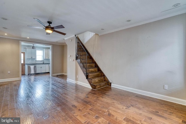 unfurnished living room featuring ceiling fan, hardwood / wood-style floors, and ornamental molding