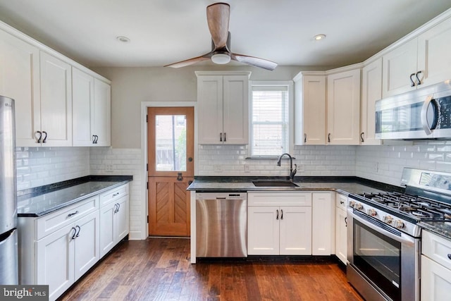 kitchen with ceiling fan, backsplash, dark hardwood / wood-style floors, sink, and stainless steel appliances