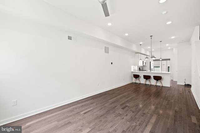 unfurnished living room with ceiling fan and wood-type flooring