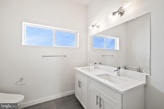 bathroom featuring dual vanity, toilet, and tile patterned floors