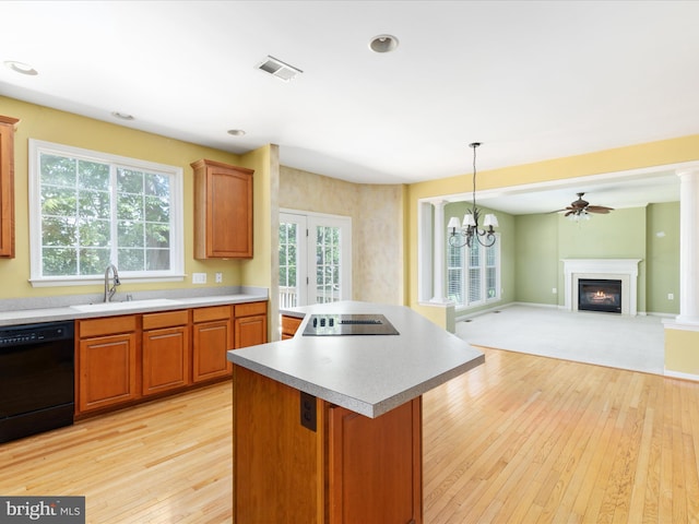 kitchen with a healthy amount of sunlight, black appliances, decorative light fixtures, and sink