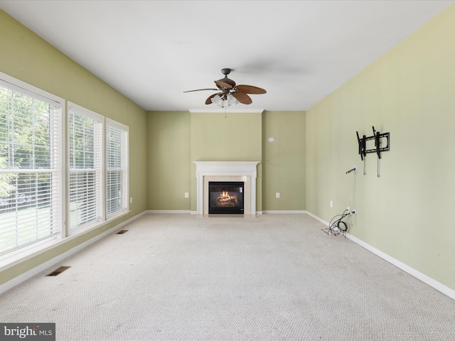 unfurnished living room with ceiling fan and carpet floors