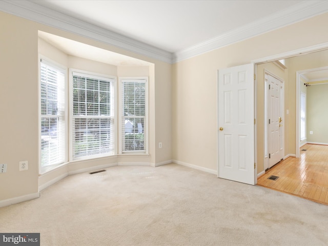 unfurnished room with light hardwood / wood-style flooring and crown molding