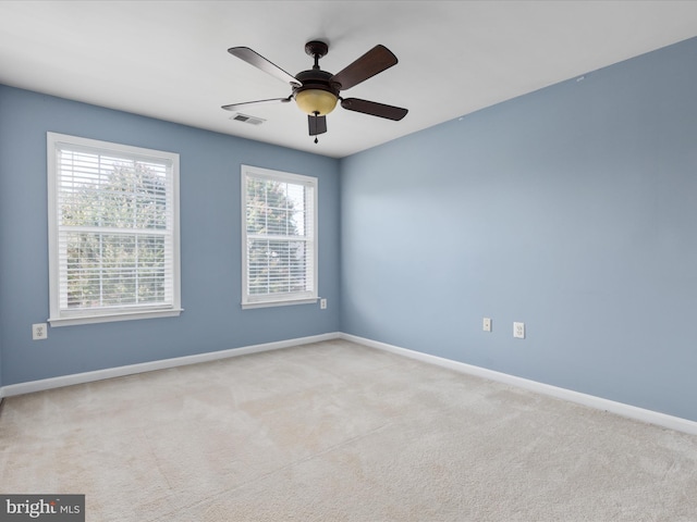 carpeted spare room featuring ceiling fan