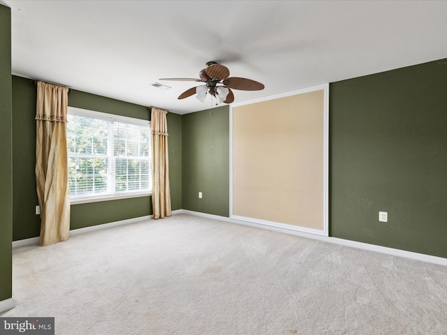 spare room featuring ceiling fan and light colored carpet