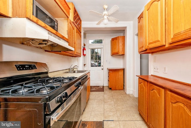 kitchen featuring light tile patterned flooring, stainless steel range with gas cooktop, sink, and ceiling fan