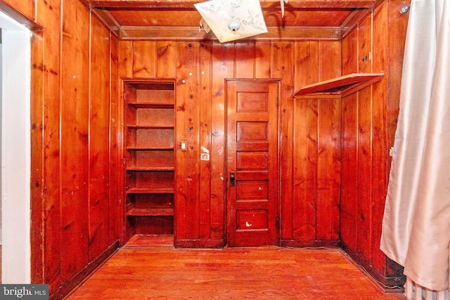 interior space featuring hardwood / wood-style flooring, built in features, and wooden walls