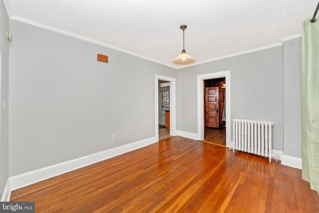 spare room with ornamental molding, hardwood / wood-style floors, and radiator heating unit